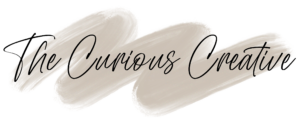 Logo of "The Curious Creative," featuring elegant typography on a soft beige brushstroke background, representing creativity and artistic expression.